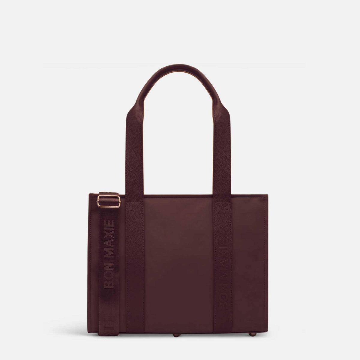 Load video: Woman demonstrating medium nylon leather tote in chocolate