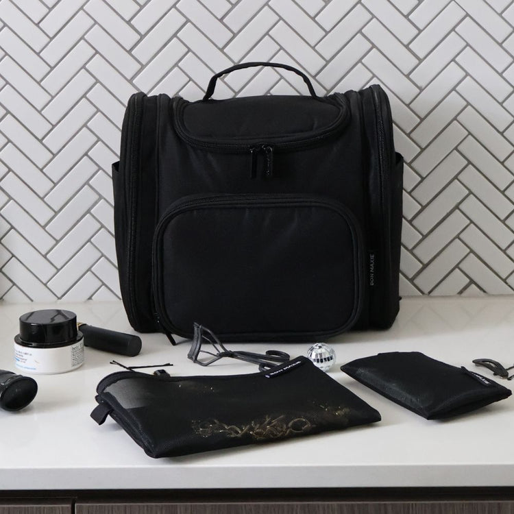 Bon Maxie large toiletry bag in black, sitting on bench