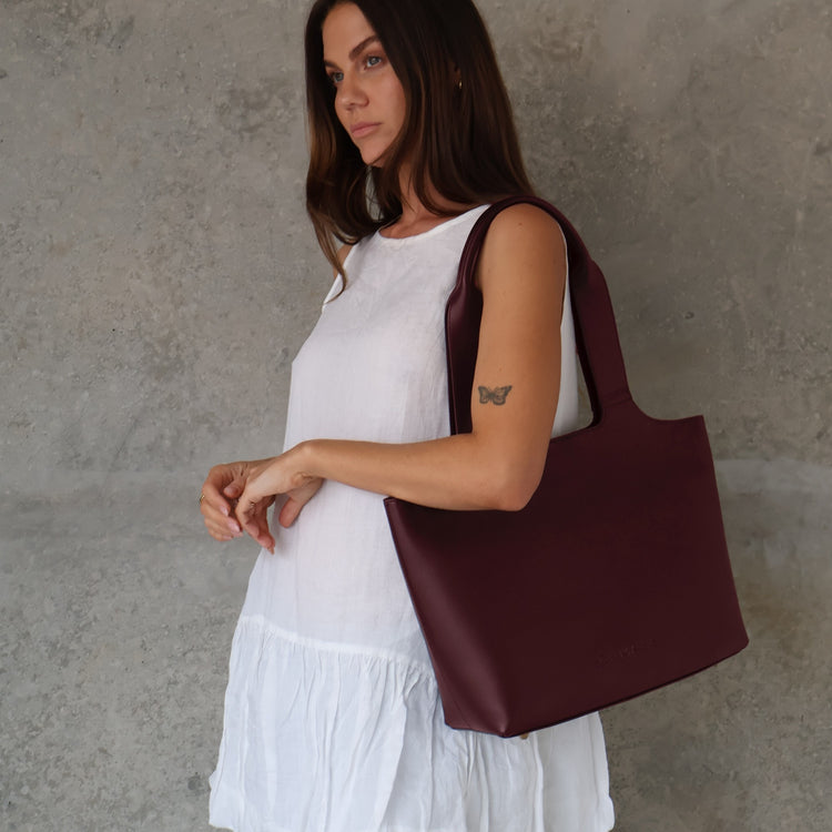 Maven Tote in Burgundy Nappa Leather, worn on the shoulder