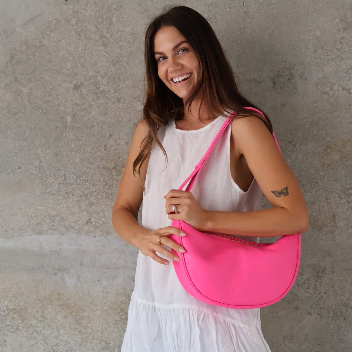 Slouchy Crescent Crossbody Bag in Neon Pink, worn crossbody