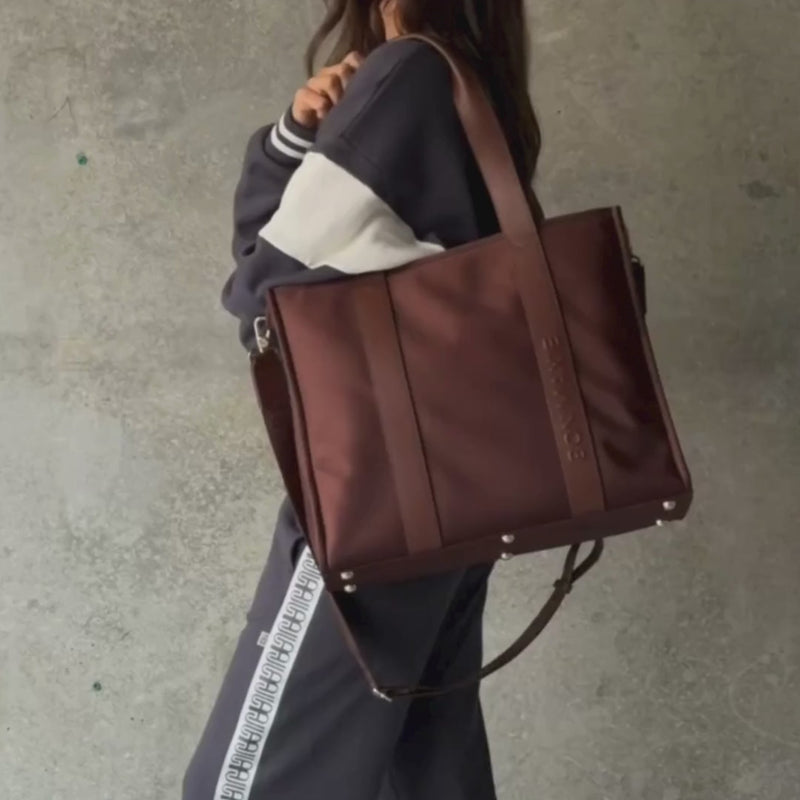 Woman demonstrating large nylon leather tote in chocolate