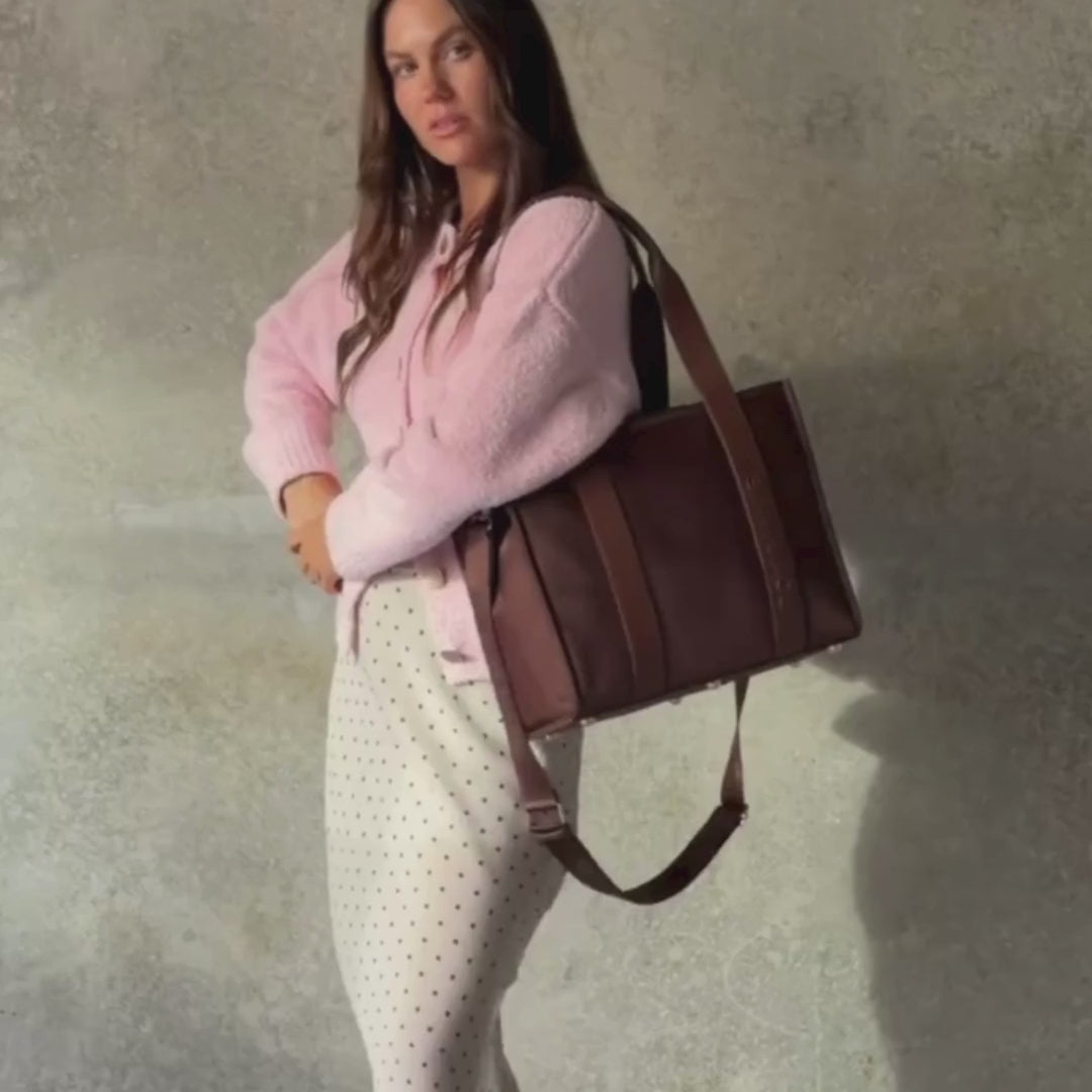 Load video: Woman demonstrating medium nylon leather tote in chocolate