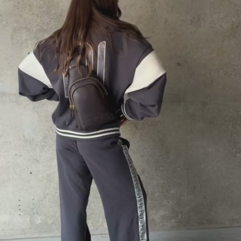Woman demonstrating multiwear crossbody bag in chocolate